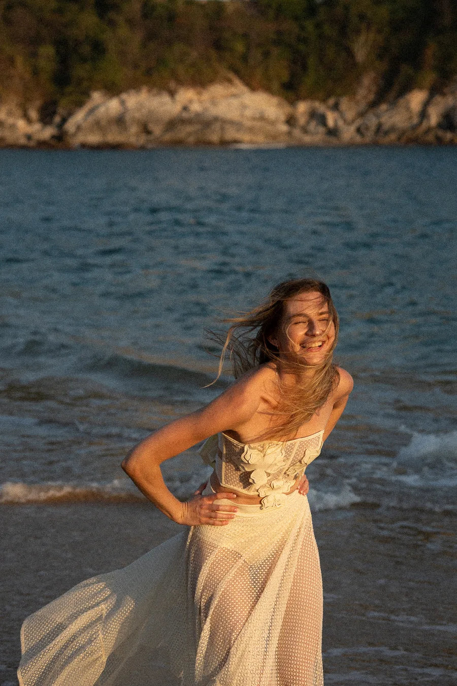 Ari laughing on the beach at golden hour in Huatulco